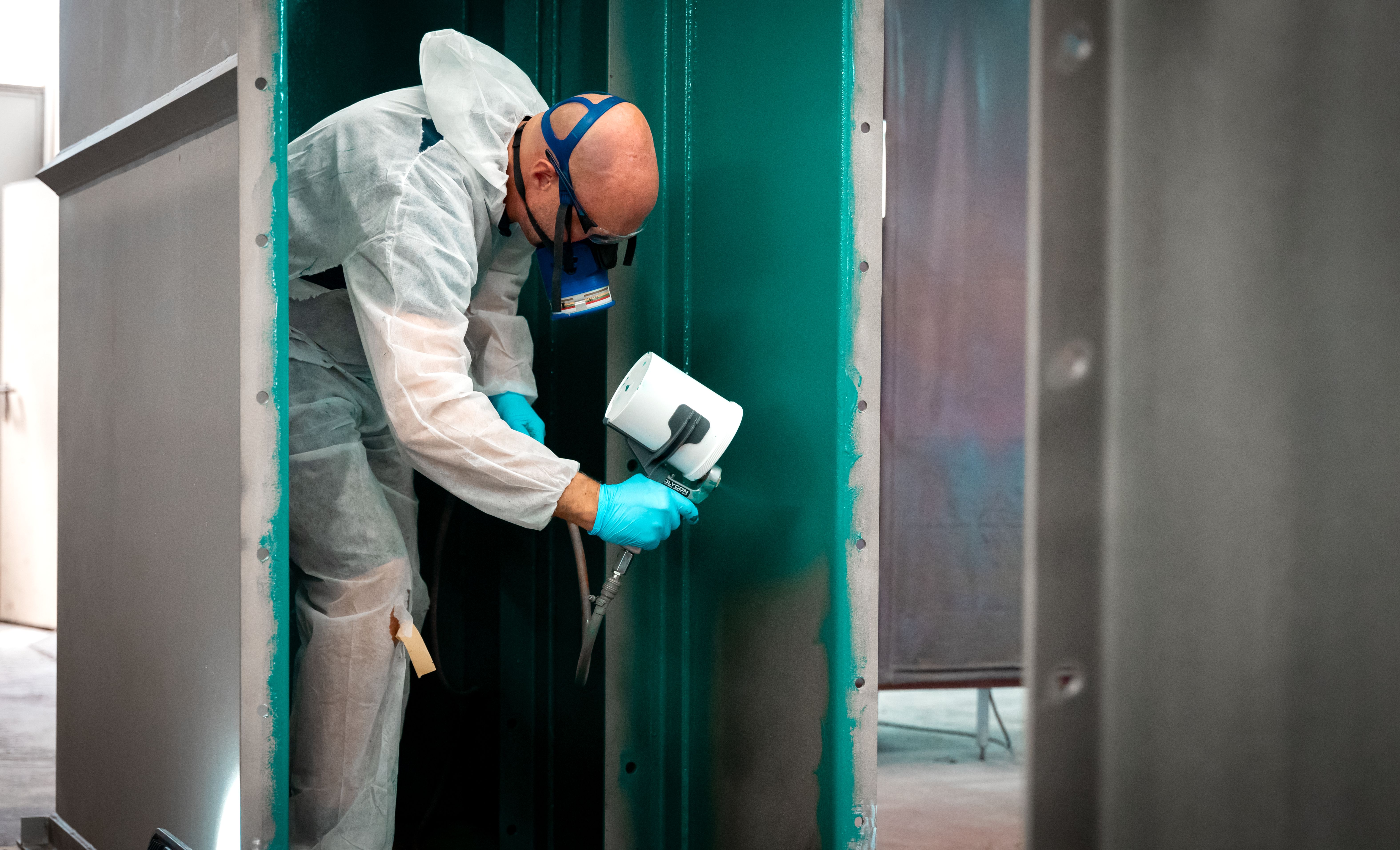 Um homem com máscara pulveriza uma camada de controlo verde